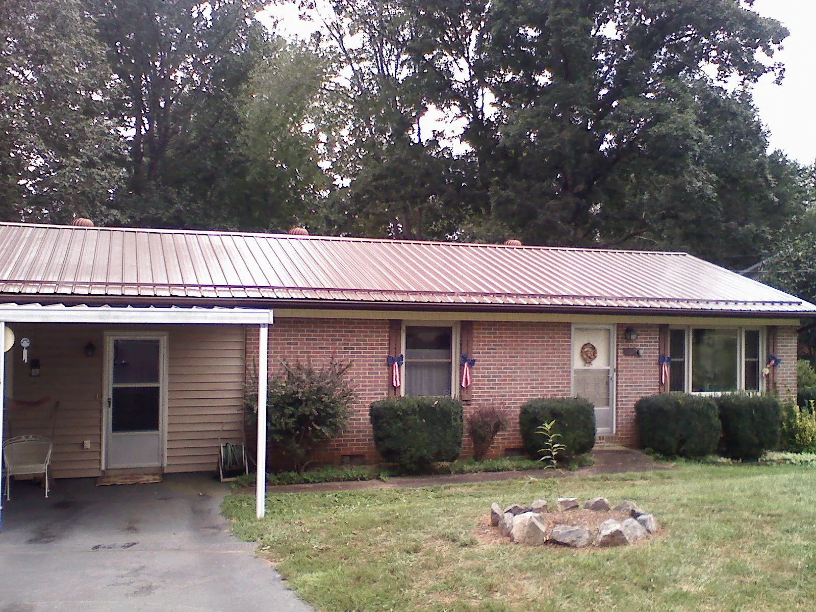 Bronze metal roof and carport on a brick ranch home — Roof Repair work by our crew in Woodhaven